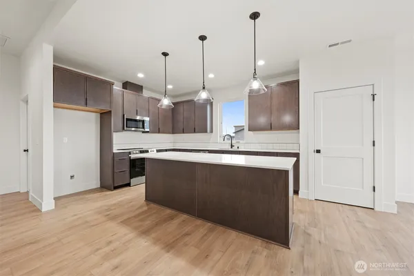 a kitchen with kitchen island a sink stainless steel appliances and cabinets