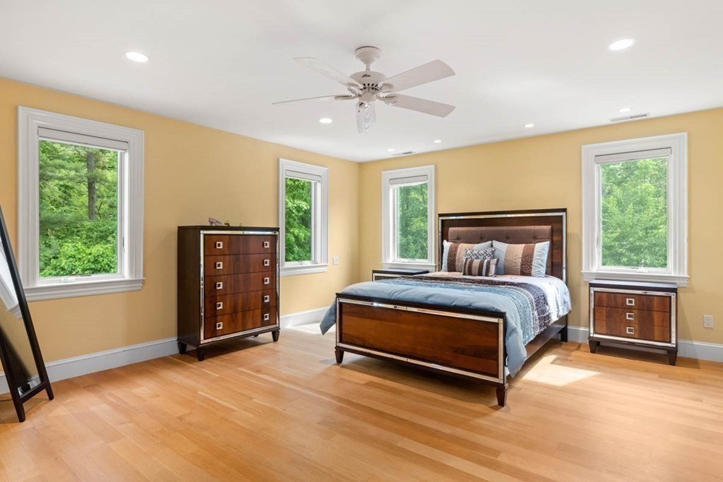 19 Ross Lane Middleton, MA 01949 - Photo 27 of 42 a bedroom with a bed and a chandelier
