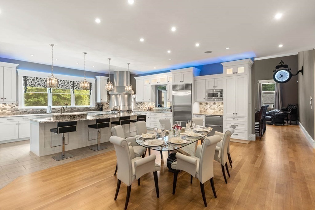 19 Ross Lane Middleton, MA 01949 - Photo 9 of 42 a kitchen with stainless steel appliances kitchen island granite countertop a table and chairs in it