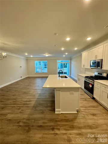 a large kitchen with stainless steel appliances kitchen island a large counter top and a stove top oven