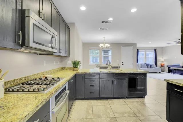a large kitchen with stainless steel appliances granite countertop a stove and a sink