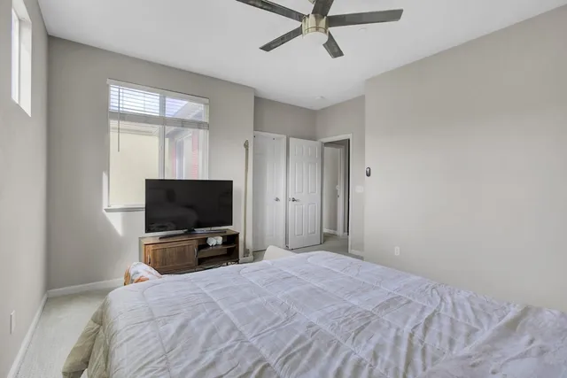 a bedroom with a bed and a flat tv screen on wall