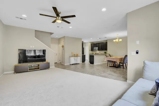 a living room with furniture and a flat screen tv with kitchen view