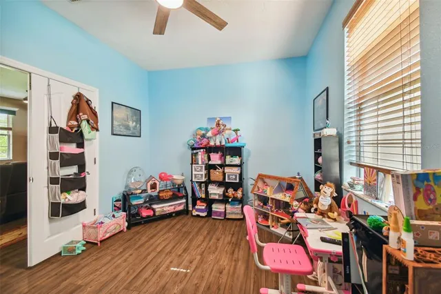 a very nice looking room with many windows and a ceiling fan