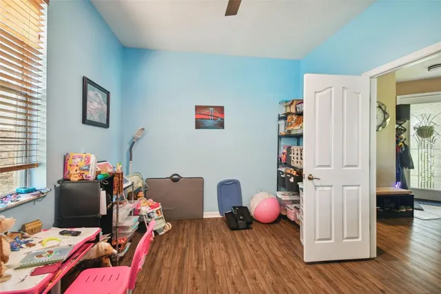 a playing room with furniture and wooden floor