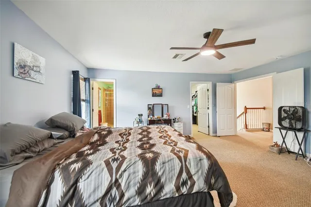a bedroom with a large bed and a chandelier