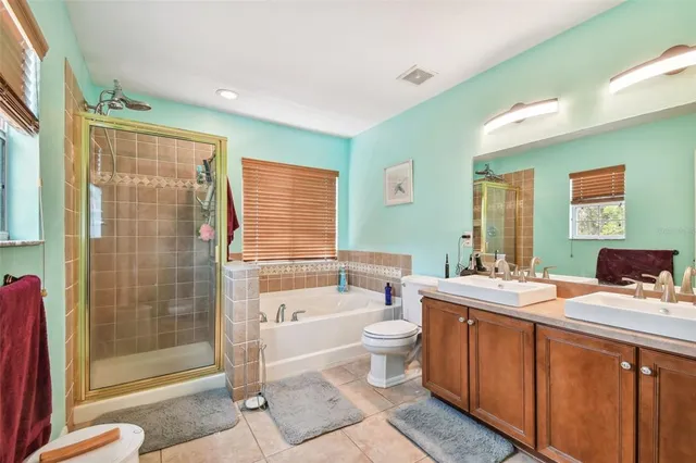 a bathroom with a double vanity sink toilet and shower