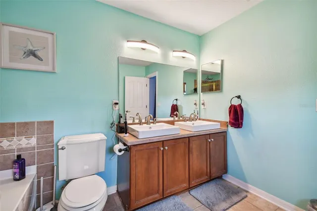 a bathroom with a toilet sink vanity and mirror
