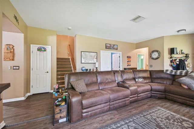 a living room with furniture and a wooden floor