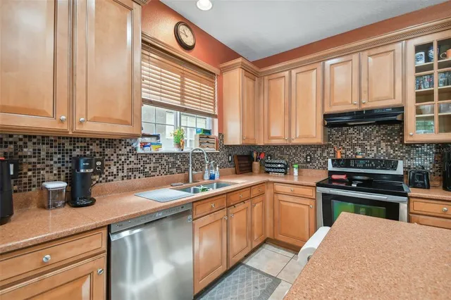 a kitchen with stainless steel appliances granite countertop a sink a stove and cabinets