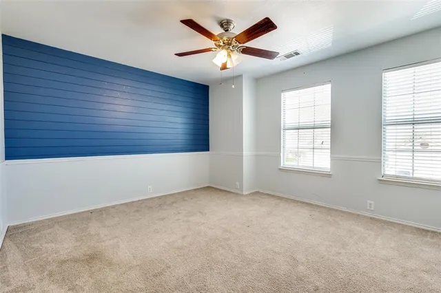an empty room with windows and fan