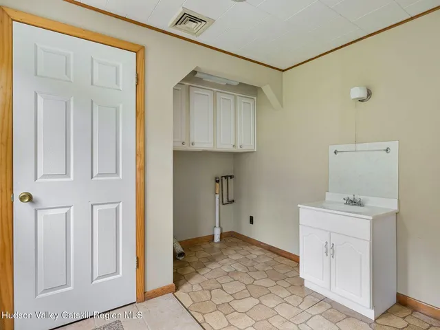 a view of an empty room with window and cabinet