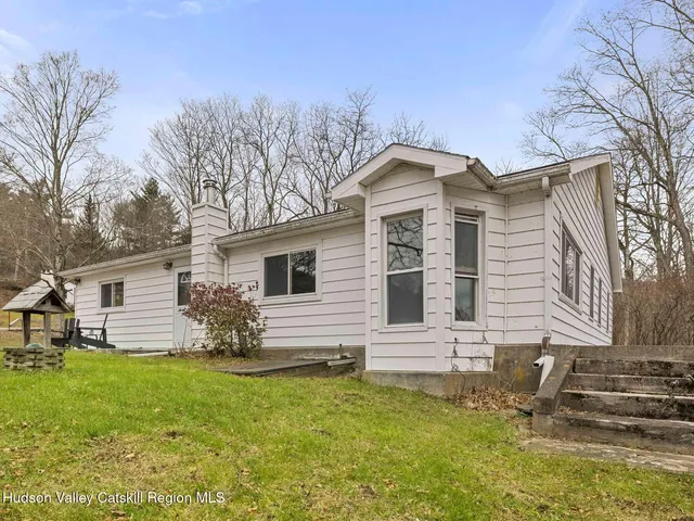 a view of a patio with table and chairs near a barbeque