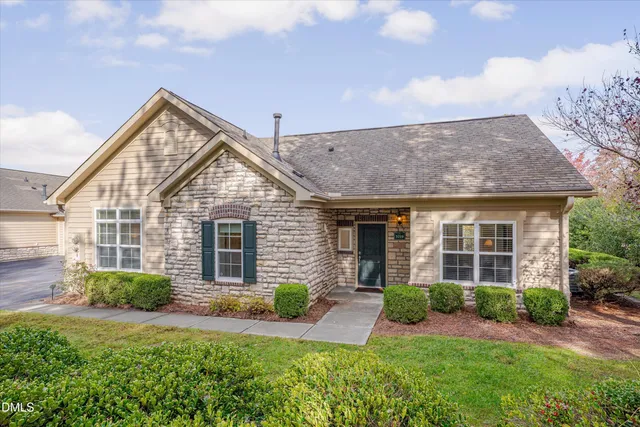 a front view of a house with yard and green space
