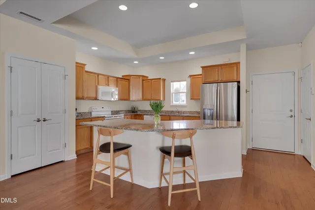 a kitchen with stainless steel appliances granite countertop a refrigerator and a stove top oven
