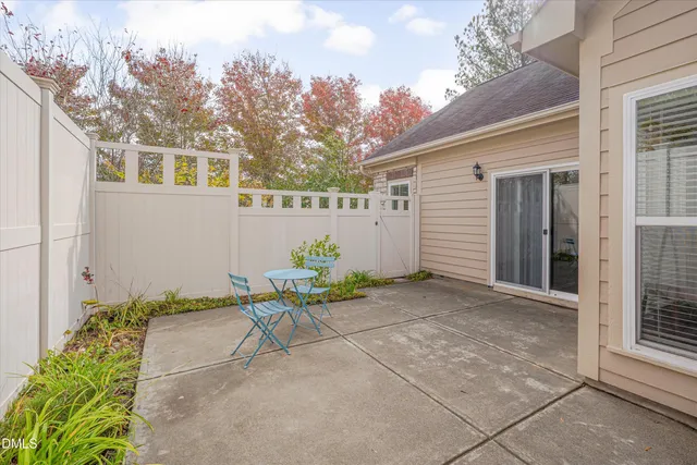 a view of a chair and table in backyard of the house