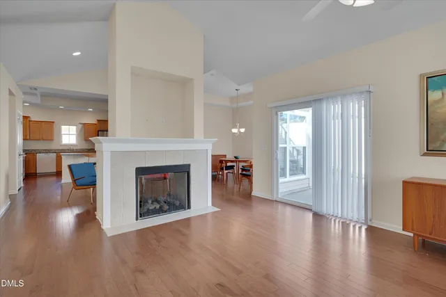 a view of a livingroom with wooden floor and a fireplace
