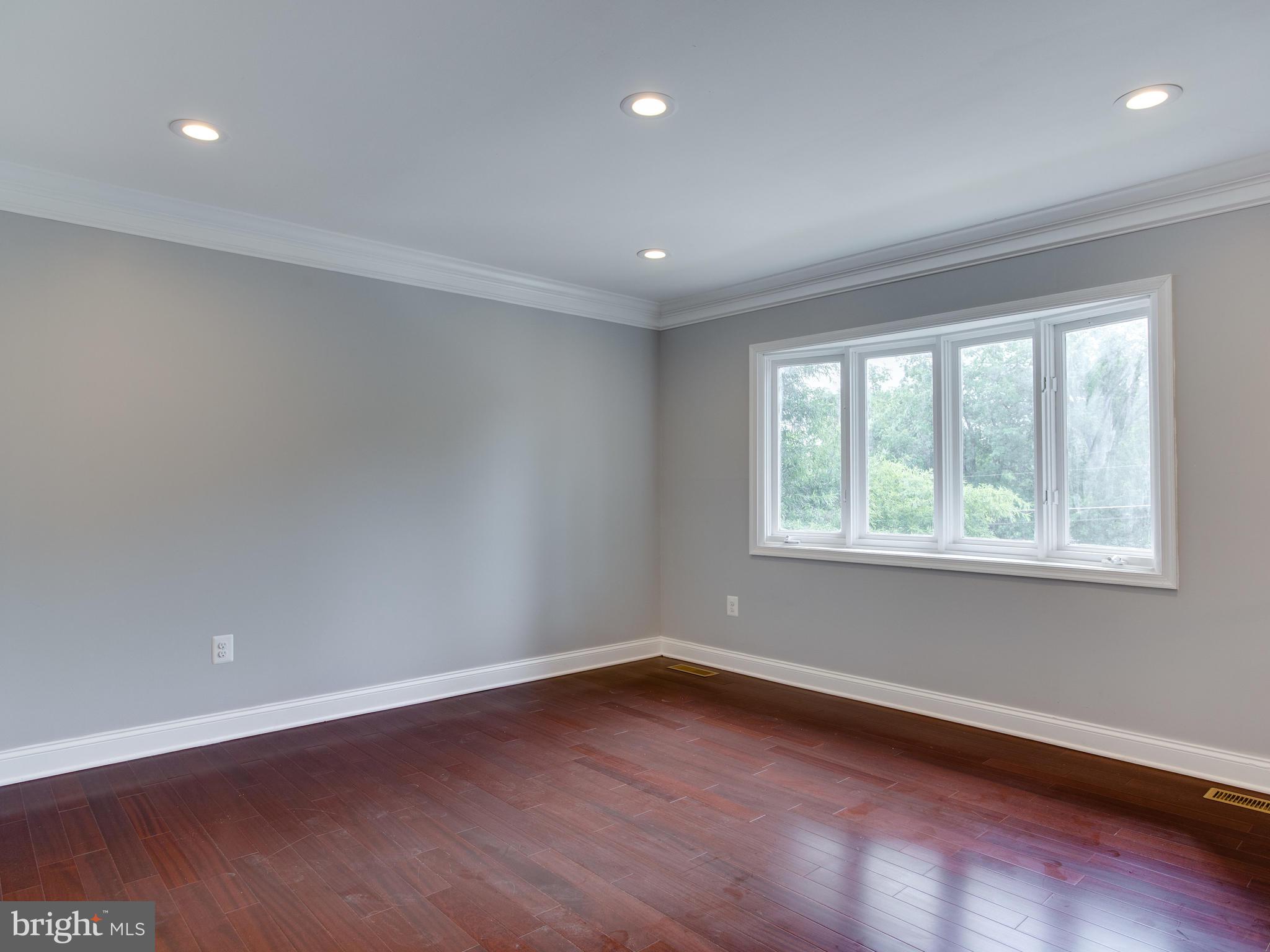 6006 Queens Chapel Road Hyattsville, MD 20782 - Photo 4 of 19 an empty room with wooden floor and windows