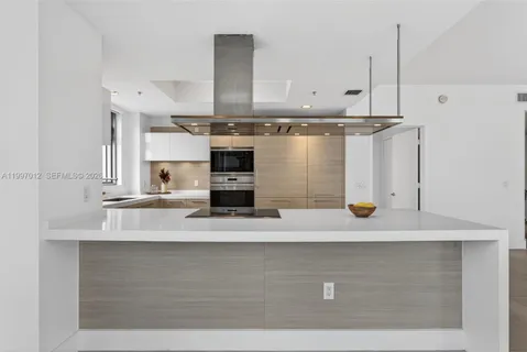 a kitchen with stainless steel appliances granite countertop a sink stove and white cabinets