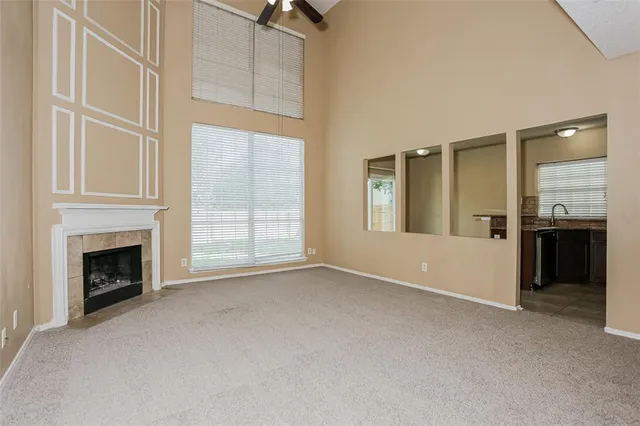 an empty room with windows and fireplace