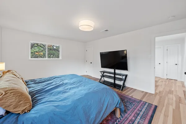 a bedroom with a bed and a flat screen tv