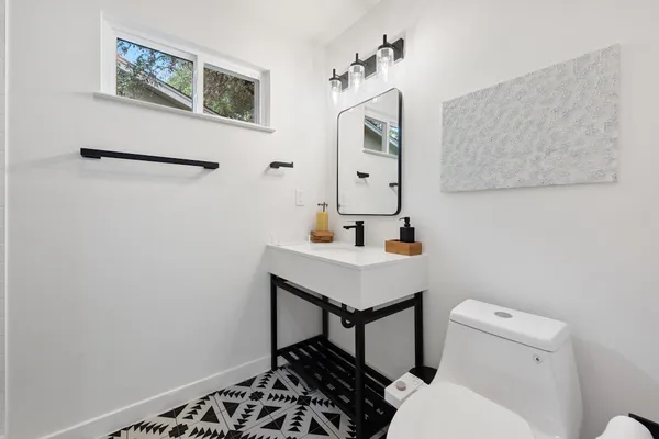 a bathroom with a toilet a sink and a mirror