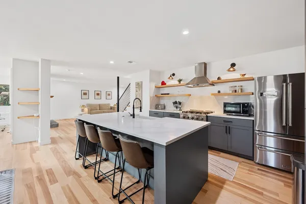 a kitchen with kitchen island a sink stove and refrigerator