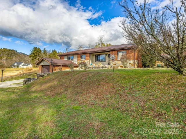 a view of a house with a big yard and large trees