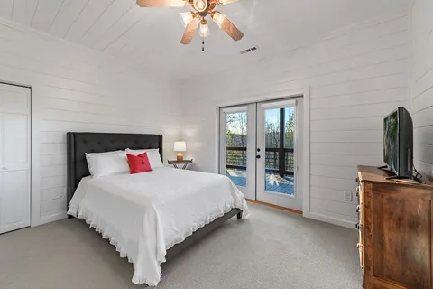 a bedroom with a large bed and a flat tv screen