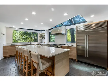 a kitchen with stainless steel appliances granite countertop a sink a stove and a refrigerator