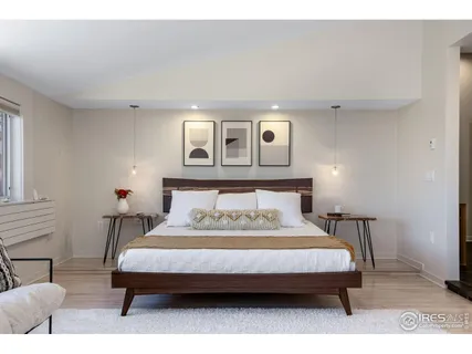 a bedroom with a bed wooden floor and window