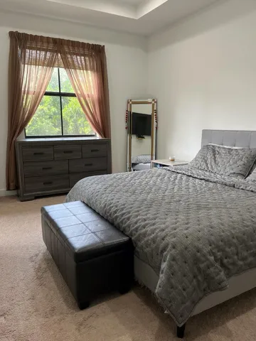 a bedroom with a bed and a window