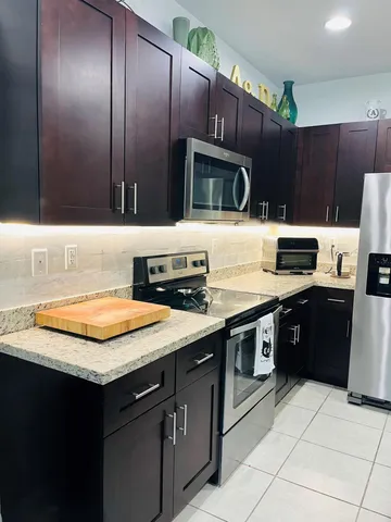 a kitchen with stainless steel appliances granite countertop a sink and a stove