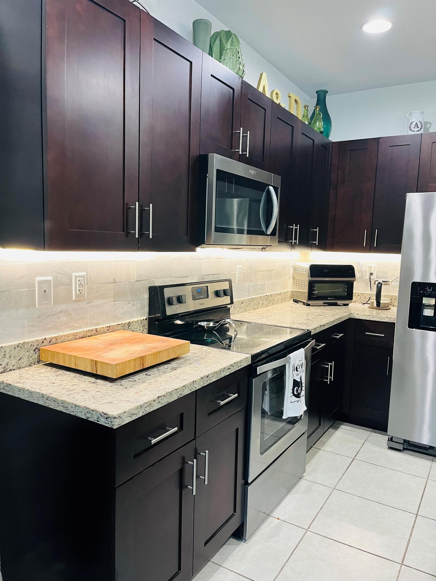 5211 Northwest 50th Terrace Tamarac, FL 33319 - Photo 8 of 15 a kitchen with stainless steel appliances granite countertop a sink and a stove