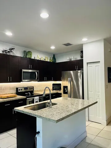 a kitchen with stainless steel appliances granite countertop a sink and a stove