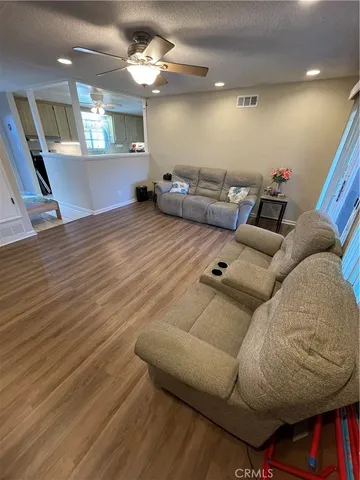 a living room with furniture and a wooden floor