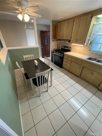 a living room with couches and kitchen view with wooden floor