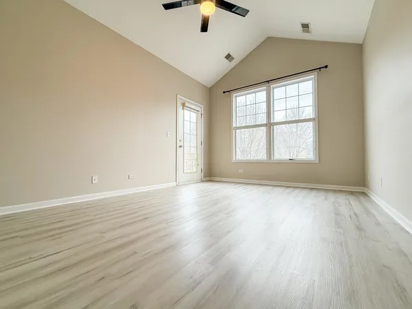 a view of an empty room with wooden floor