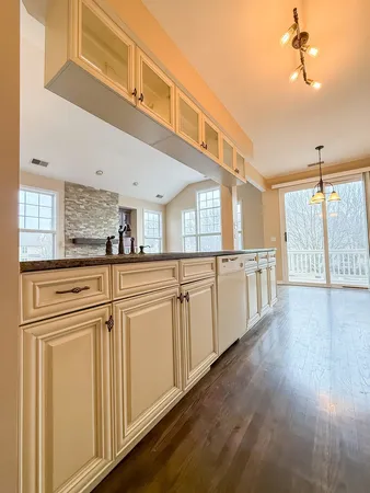 an empty room with wooden floor fireplace and windows