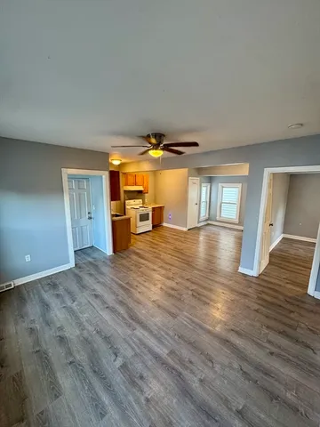 a view of empty room with wooden floor