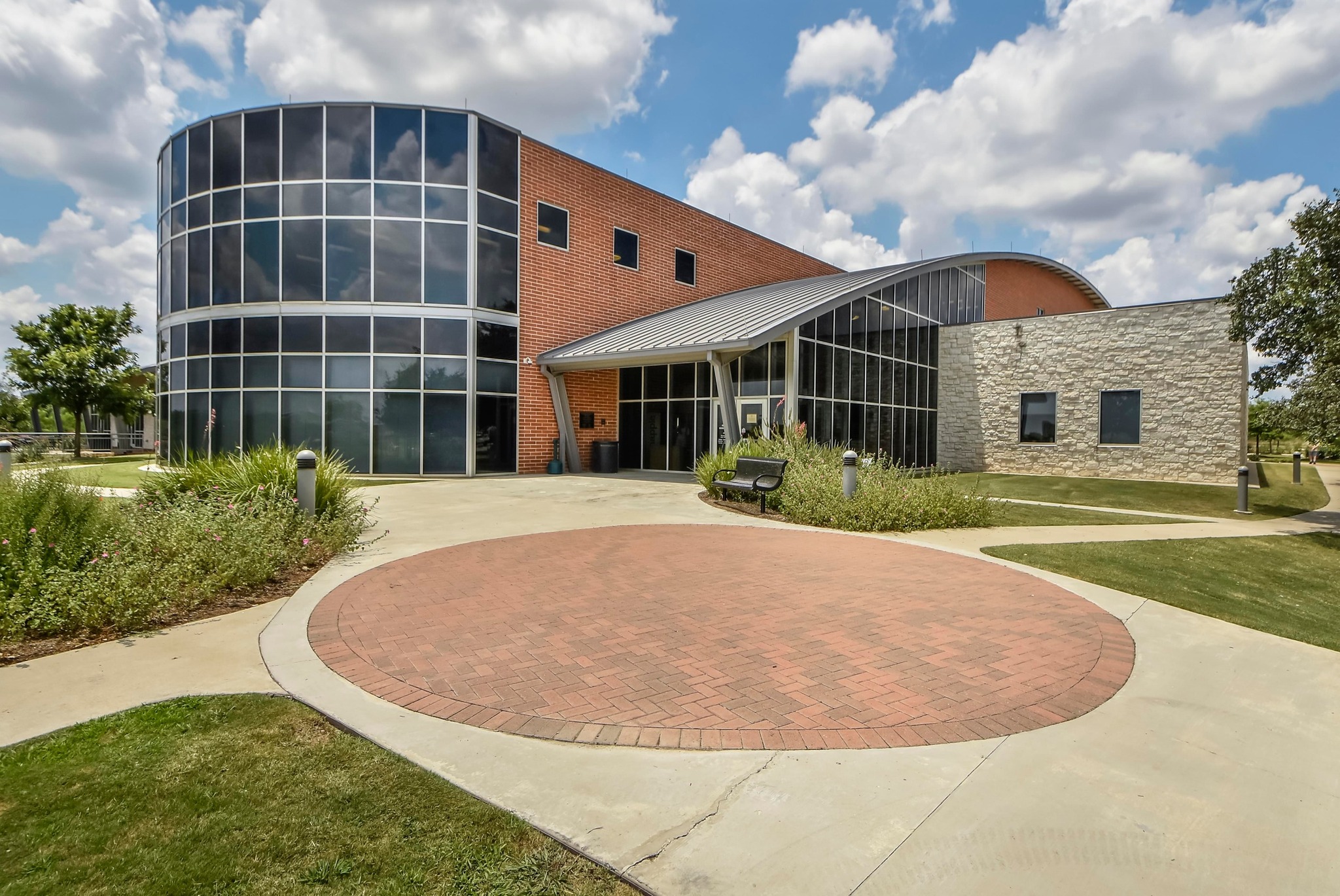 1818 Lost Maples Loop Cedar Park, TX 78613 - Photo 35 of 38 A modern building showcases expansive glass and brick construction, highlighted by a distinctive circular brick patio.
