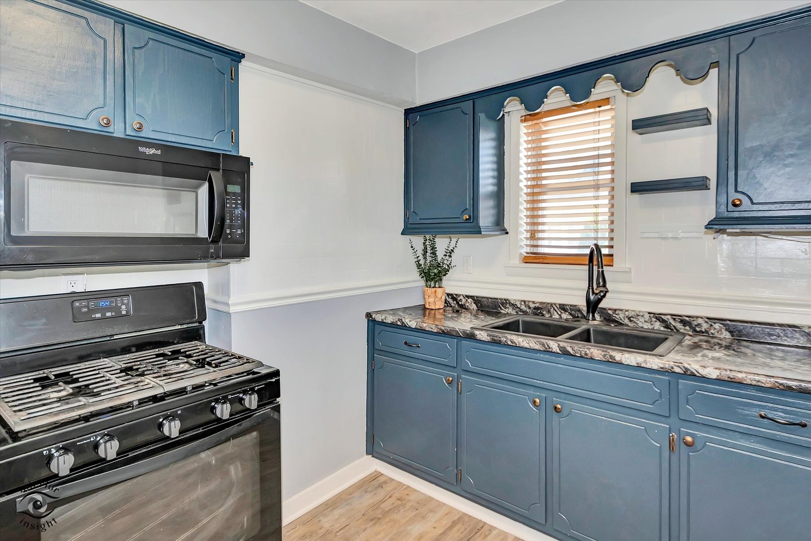 7515 West 61st Street Summit, IL 60501 - Photo 8 of 32 a kitchen with granite countertop a stove and a microwave