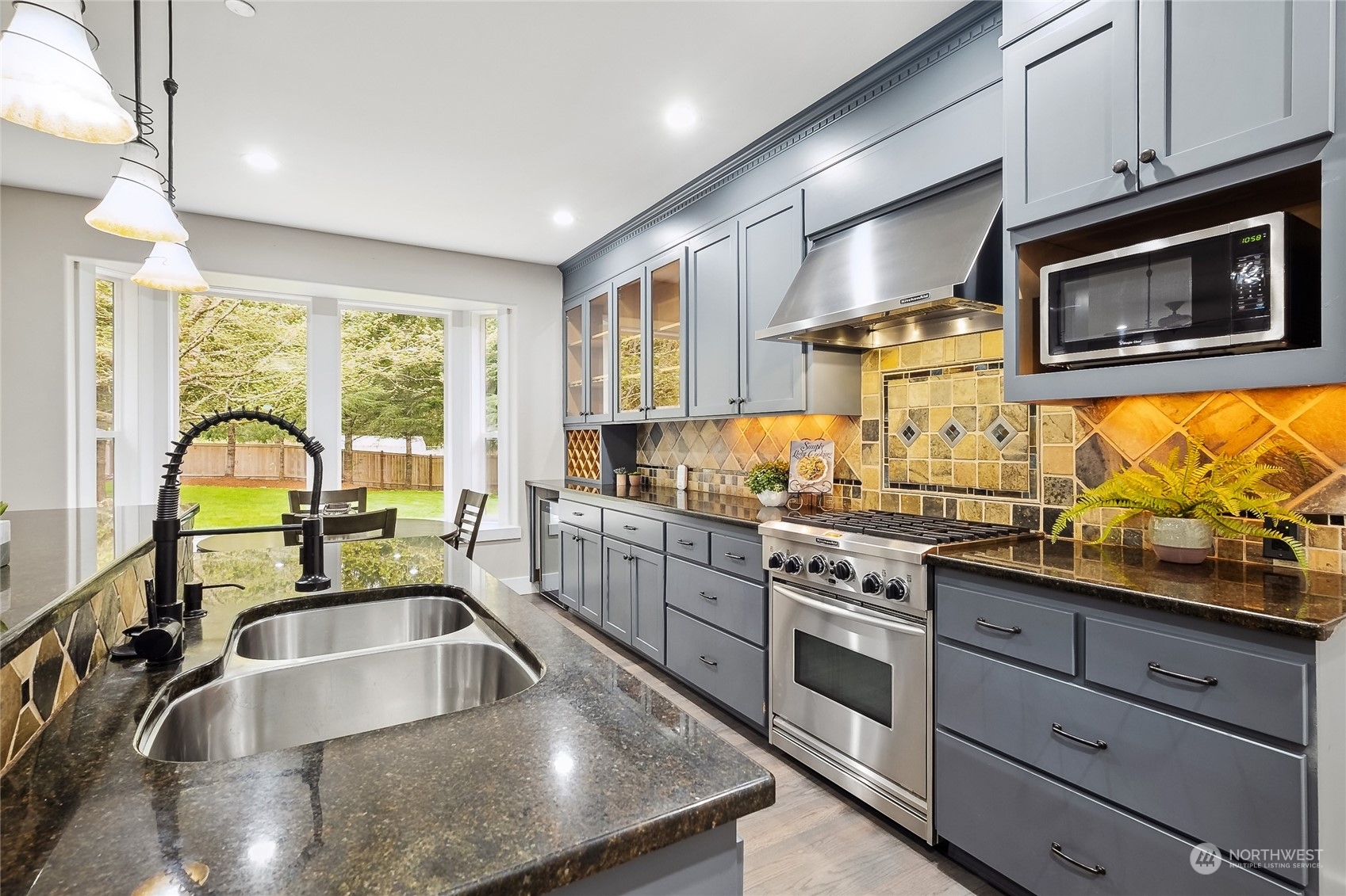 24827 247th Place Southeast Maple Valley, WA 98038 - Photo 8 of 33 a kitchen with stainless steel appliances a stove sink and cabinets