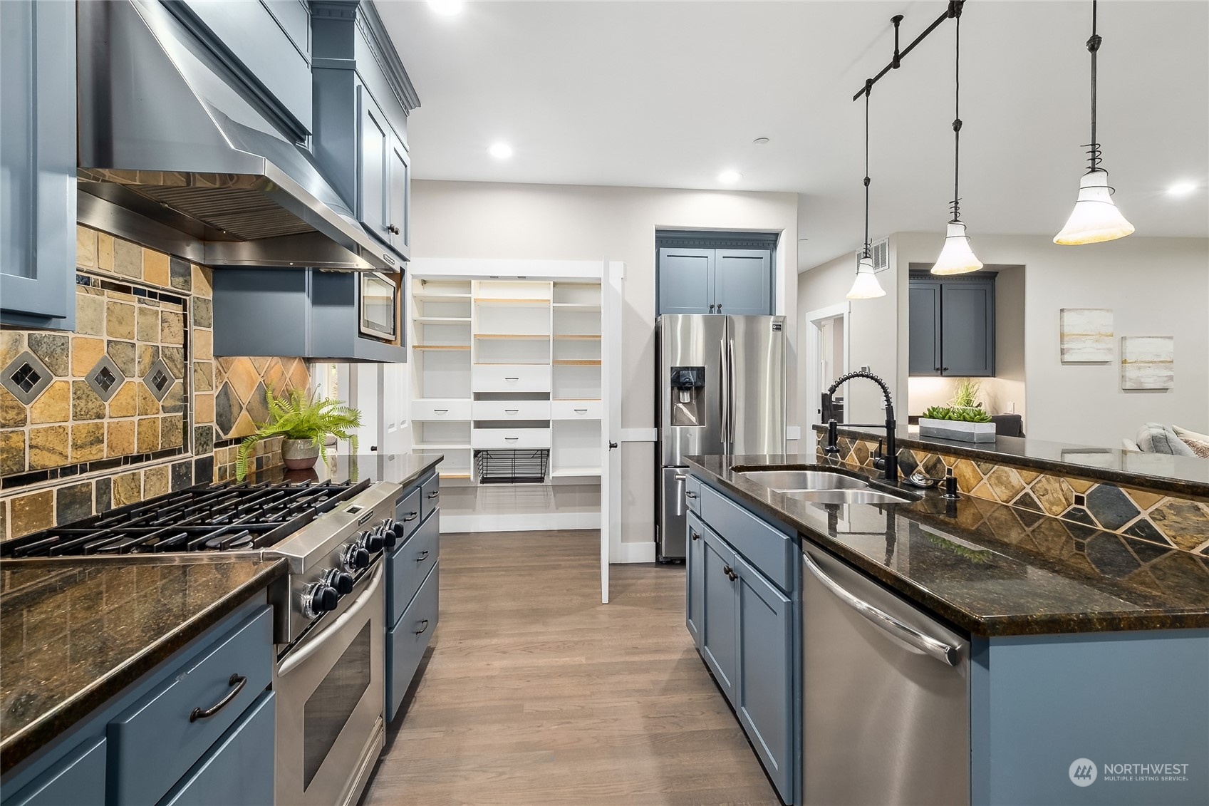 24827 247th Place Southeast Maple Valley, WA 98038 - Photo 10 of 33 a kitchen with stainless steel appliances a sink a stove and a wooden floors