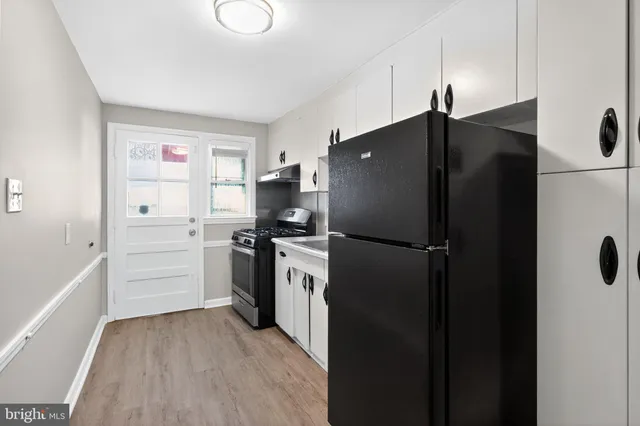 a kitchen with a refrigerator and a stove top oven