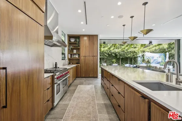a kitchen with stainless steel appliances granite countertop a sink a stove and a refrigerator