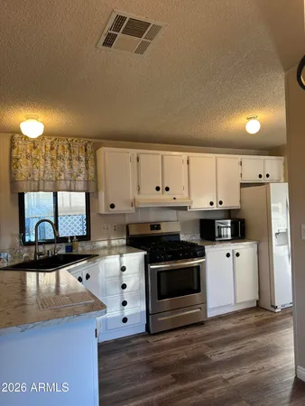 a kitchen with stainless steel appliances granite countertop a stove a sink and a microwave