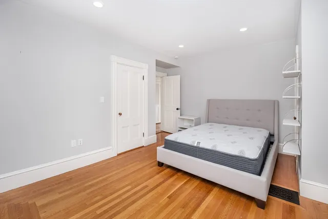 a room with a bed and a wooden floor