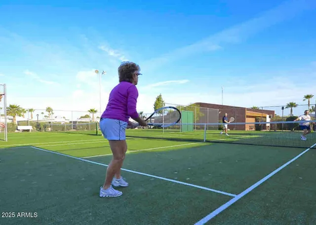 a view of a pool with lawn chairs and a yard