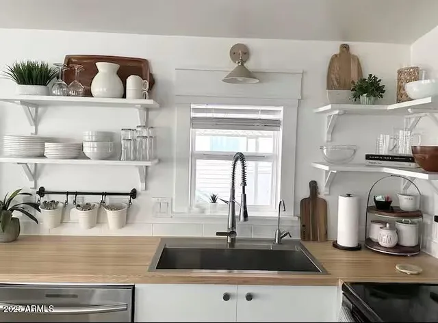 a kitchen with a sink a stove and cabinets